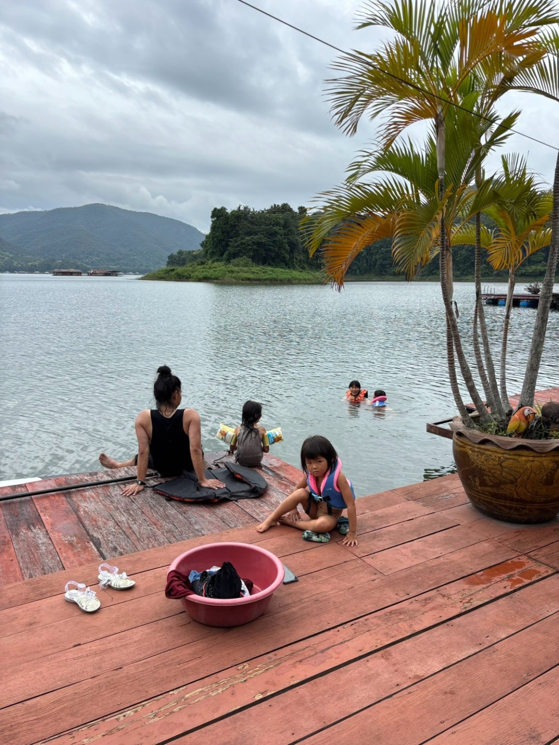 湖で遊ぶ人たちと木のデッキ